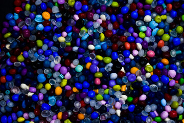 Various colors of mixed masterbatch granules, isolated on a black background, this polymer is a...