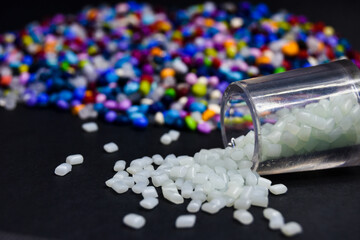 Various colors of mixed masterbatch granules, isolated on a black background, this polymer is a...