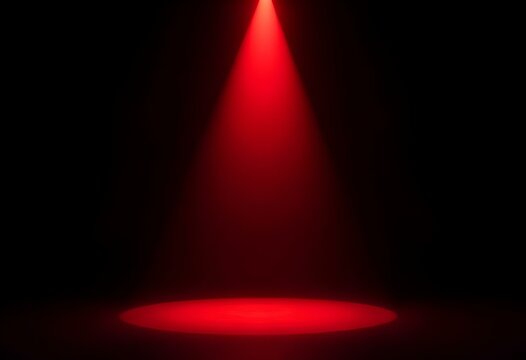 A single red spotlight shining down onto a black stage, with the focus on a black object in the center. The light creates a dramatic spotlight effect, enhancing the object's features create with ai