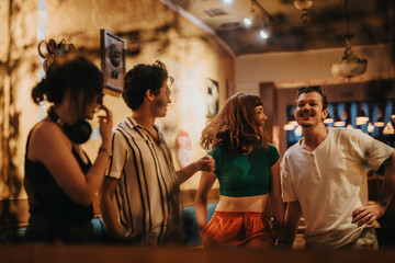 Obraz premium A group of young friends laughing and chatting in a warm, inviting cafe. The casual atmosphere and connection create a joyful social scene filled with fun and friendship.