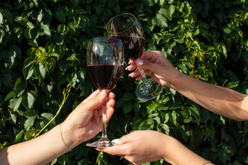 Hands holding glasses with wine	