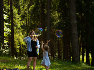 young girl blows beautiful and big soap bubbles