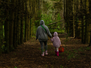 mother and daughter picking mushrooms in the forest