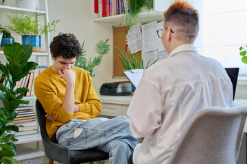 Young male patient in therapy with psychologist counselor in office