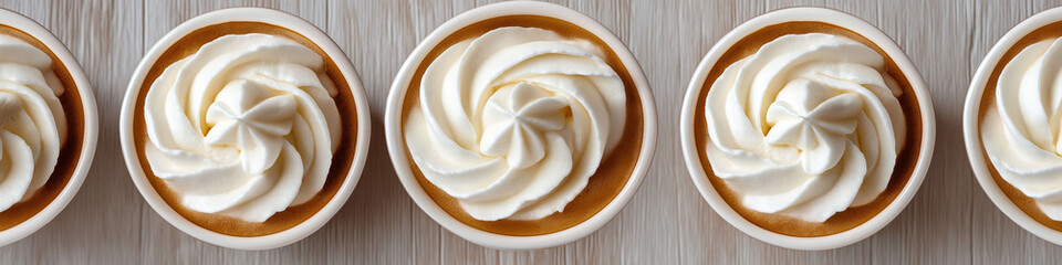 Rows of coffee cups with whipped cream topping, creating a visually pleasing pattern arrangement concept