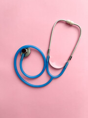 Doctor concept. Top view of stethoscope on pink background with space for text or promotion