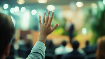 Businessman raises his hand to inquire during a business conference presentation