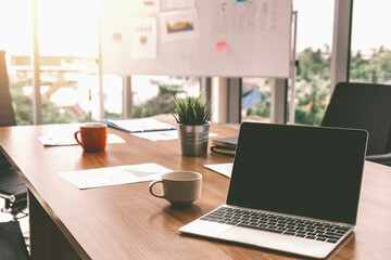 Laptop computer with opened lid on table in meeting room of office workspace. uds