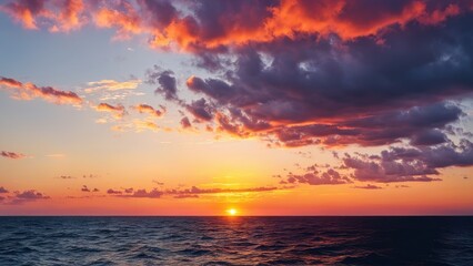 Fototapeta premium A vibrant sunset over the ocean, blending colors of orange, pink, and purple in the sky.