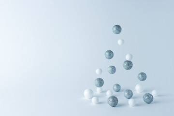 Christmas tree made of silver and white decoration on white background. Minimal Christmas or New Year concept.