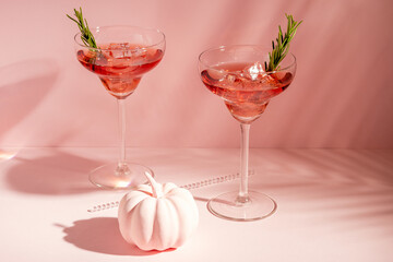 Halloween minimal concept with pink pumpkin and cocktails. Creative holiday party background.