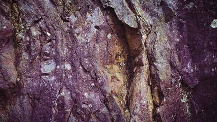Textured 4K image of rugged stone in shades of purple, brown, and gray, offering a natural, grainy surface perfect for backgrounds, banners, and creative designs
