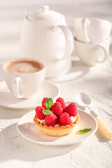 Tasty mini tart made of cream and raspberries.