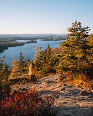 Epic Female Hiker Stands on Rock Edge in Acadia National Park Sunrise Beech Mountain Beautiful Wide Landscape During Fall Foliage in Maine