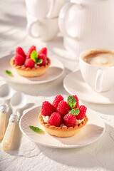 Delicious mini tart made of cream and raspberries.