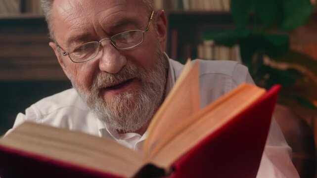 Old Caucasian man grandfather reading book novel history home library literature educated well-read pensioner aged antique business exploring information intelligence cognition page paper learn text