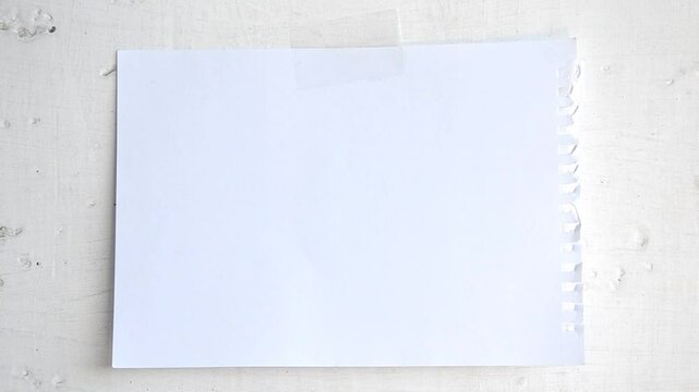 white sheet of paper is taped to the wall, fluttering in the wind