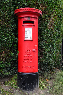 Welshpool, Wales, UK - September 6, 2024; Rare King Edward VIII cipher on red post office pillar box along hedgerow
