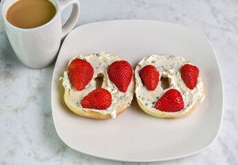 plain bagels top with cheese sprean strawberries
