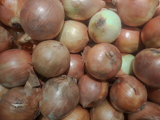 Piles of onions on display in supermarket 