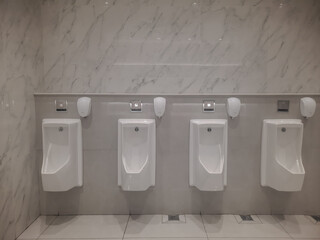 A row of urinals lined up in a shopping area 