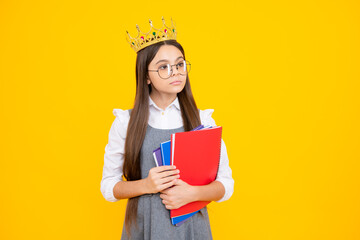 Schoolgirl nerd princess in school uniform and crown celebrating victory on yellow background....