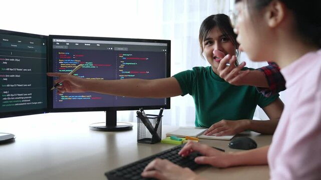 Slow motion back end software developer engineer for computer programming working together on debugging writing computing code, solving complex algorithms display on monitor in office. Burgeoning