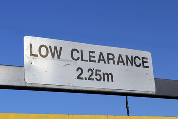 Low Clearance 2.25m height restriction sign against a blue sky background