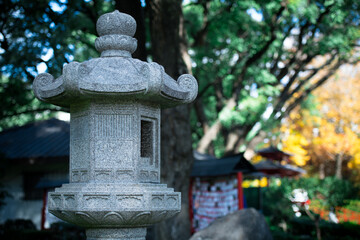 A stone lantern in the Japanese Garden of Buenos Aires, with selective focus highlighting its detailed design, surrounded by lush greenery and soft, blurred background.