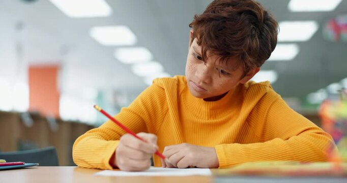 Kid, education and writing at library in school with notebook for assessment or assignment. Boy, studying and problem solving with stationery for project for child growth and brain development