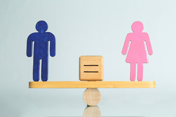 Gender equality concept. Male and female figures on scales against light background