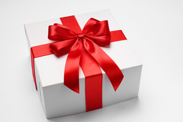 Gift box with red bow on light grey background