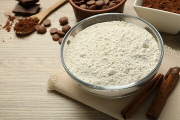 Flour, chocolate and cocoa for making dough on wooden table, closeup