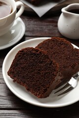 Slices of delicious chocolate sponge cake on wooden table, closeup