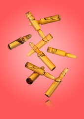Many glass ampoules falling on red gradient background