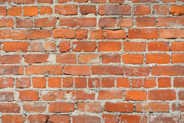 Fototapeta premium Red brick wall background with visible textures and patterns, perfect for creative projects or adding a nostalgic and timeless touch to any space.