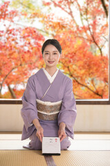 冬のお歳暮や贈り物の御礼を正座でする着物を着た女性　縦