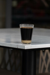Vertical Shot of Hot Oliang (Thai Black Coffee) on White Table: Bold and Rich Traditional Brew