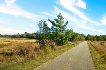 Early Autumn landscape of the Paul Bunyan Trail passing through fields and forests near Bemidji, Minnesota, USA.