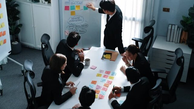 Top view business man put sticky notes on whiteboard with mind map and colorful sticky notes at meeting while business people brainstorm marketing idea. Manager choose marketing idea. Directorate.