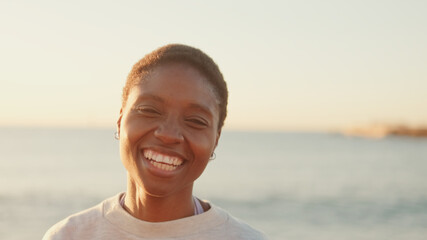 Happy girl at sunrise on the beach, turns her head and looks away