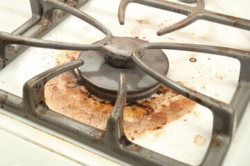 Dirty gas burner, close up. Spilled over or grease stains from cooking on gas stove top. Concept...