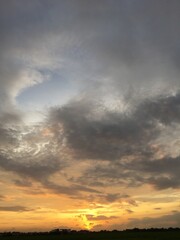 Fototapeta premium Sunset Over Fields with Cloudy Sky