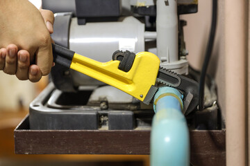 Plumber using a wrench to repair a water pipe. Concept of water pump maintenance fix water plumbing...