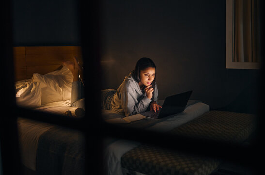 Woman, laptop and reading at night for study, learning and university in home on bed with online course. Student, technology and notebook in apartment for college exam, education and research project - Powered by Adobe