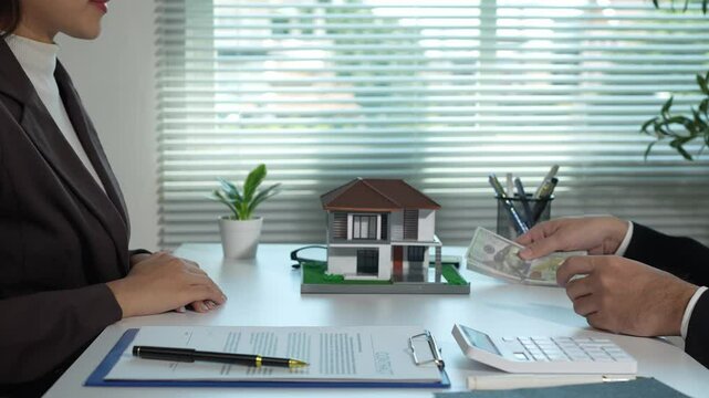 Real estate agent, collateral hire purchase, land and house broker manager, sit down to discuss details, sign contracts, and place a deposit with customers in the agent's office.