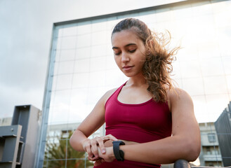 Fitness, smart watch and challenge with woman in city for running, health app and exercise tracking. Sports, workout and wellness with person for marathon practice, training plan or monitor progress