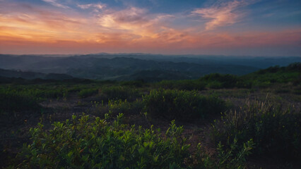 Fototapeta premium Closeup view of grassy field on hillside with colourful dusk sky with full of clouds. Beautiful nature sunset sky background.