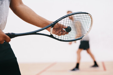 Squash, man and racket serve on court, competition and team for indoor fitness or tournament. Male person, friends and gym for physical training or workout, practice sports and athletes for exercise