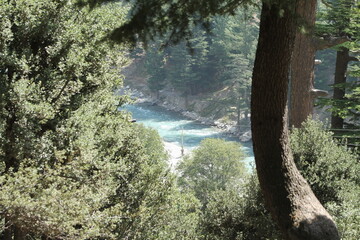 A scenic view of a winding river and lush trees as seen from the top of a mountain